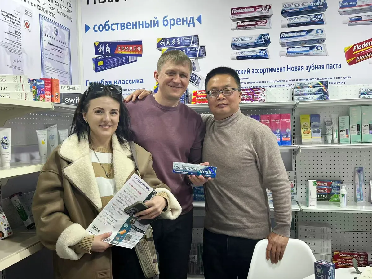 Russian buyers examining Flodentmax toothpaste with a Zongheng representative at the product shelf